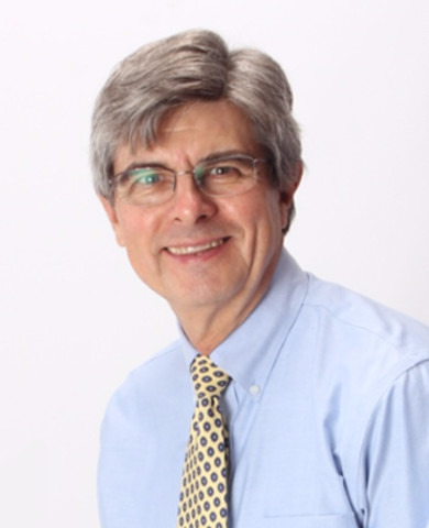Head and shoulders photo of Mark Albert, wearing a blue dess shirt and yellow tie with dark pokadots