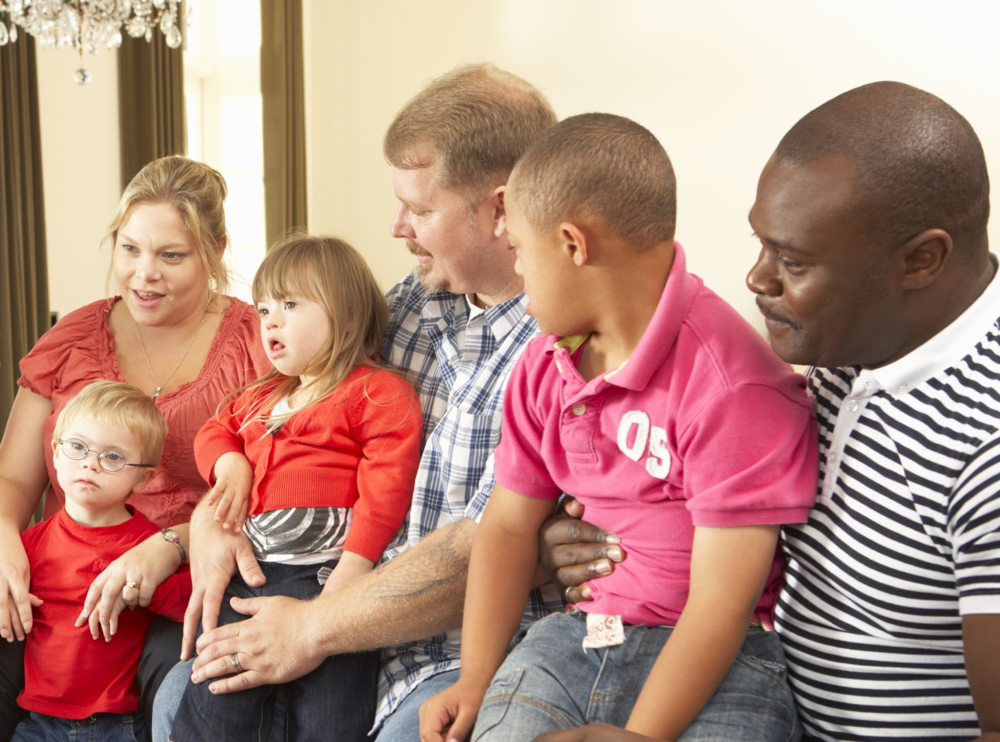 One mom and two dads, each with a young child with a disability on their lap.