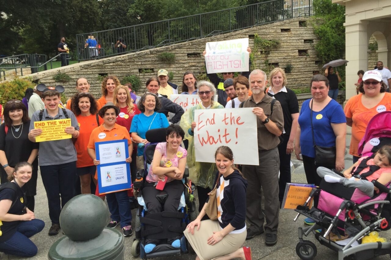 A large group of advocates and self-advocates pose at the entrance to the Virginia capital building in Richmond.