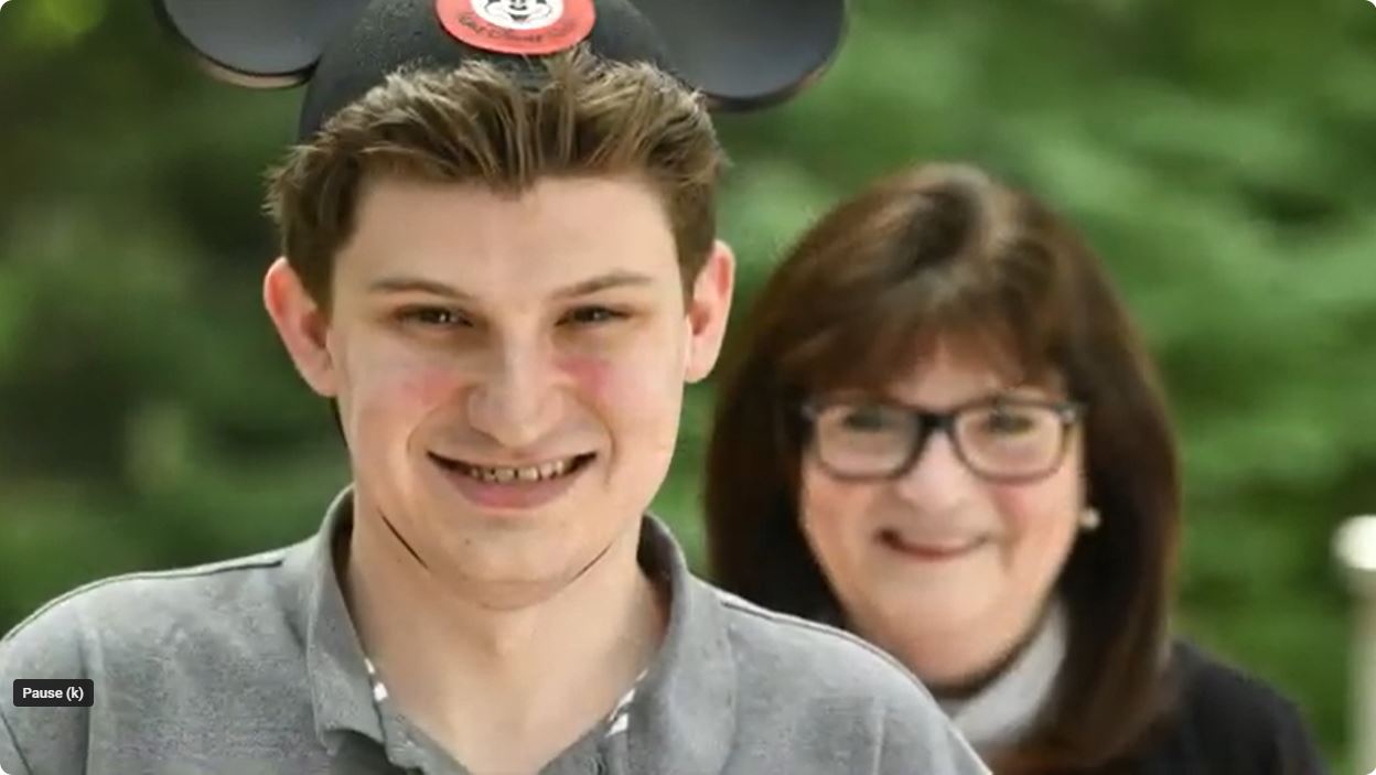 close up photo of conner cummings, wearing his mickey mouse ears, and his mother Sharon standing behind him